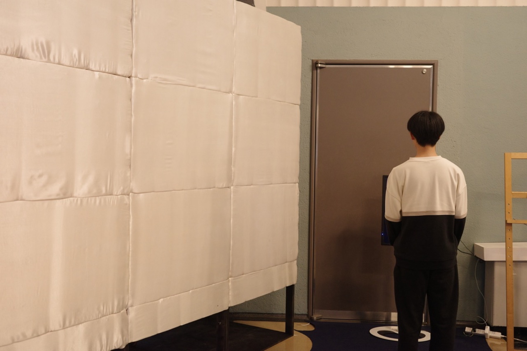 本展示会場は、柱も床も石の仕上げかつ大空間であるため、音の反響が大きい。展示空間、講演空間としては残響時間を抑える必要があるため、吸音パネルを作成した。このパネルは、渡辺翁記念会館の市松模様の床に対応するように割り付けを行った。